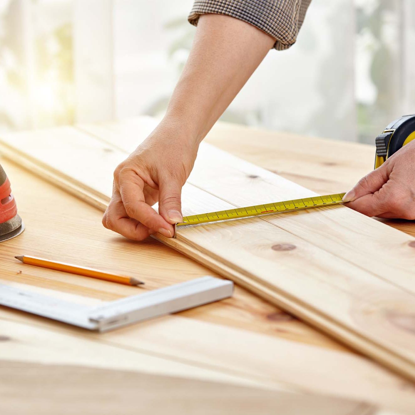 Carpenter works with wood in the workshop. A woman works in a carpentry workshop. Construction works