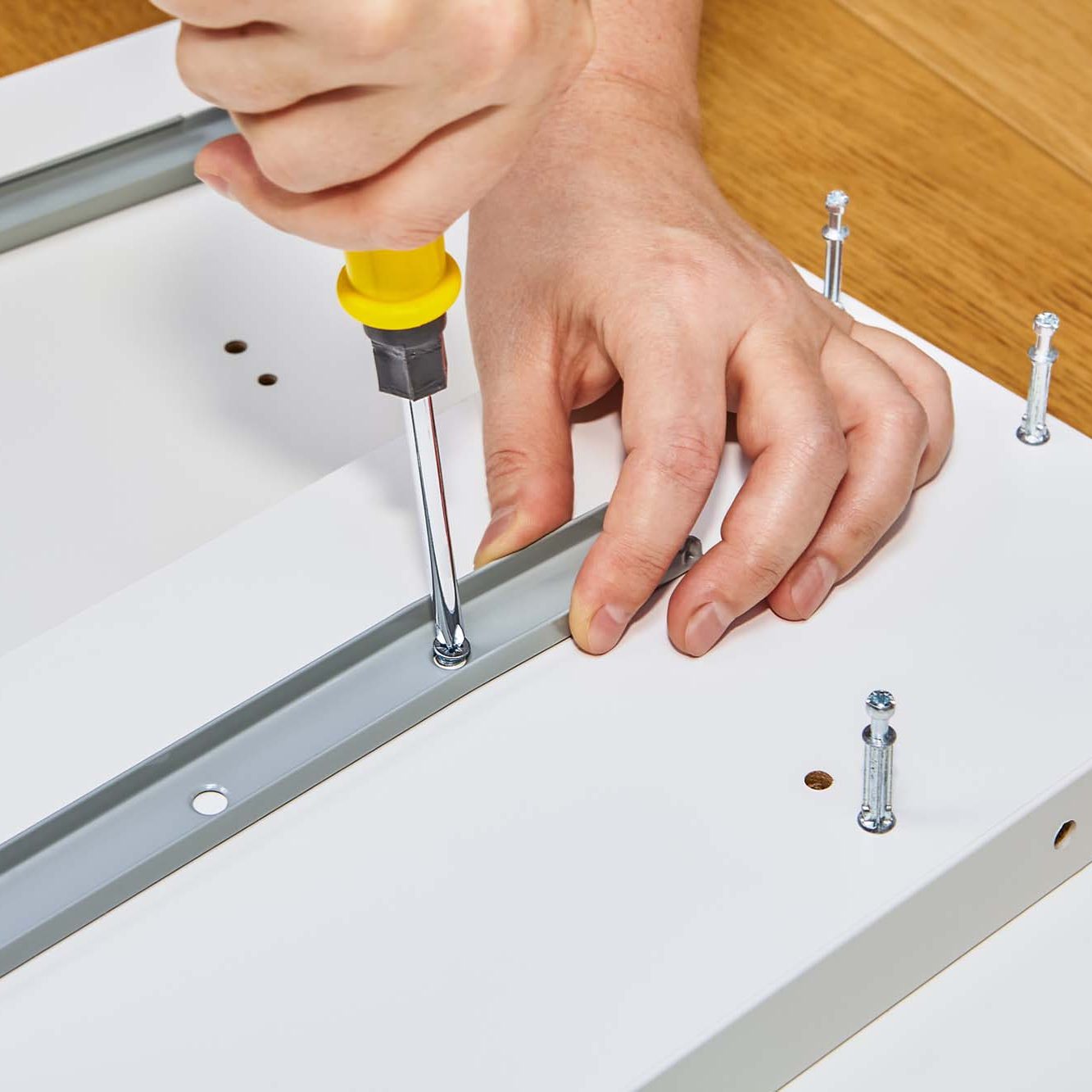 Joiner putting together self assembly furniture at home, hands c